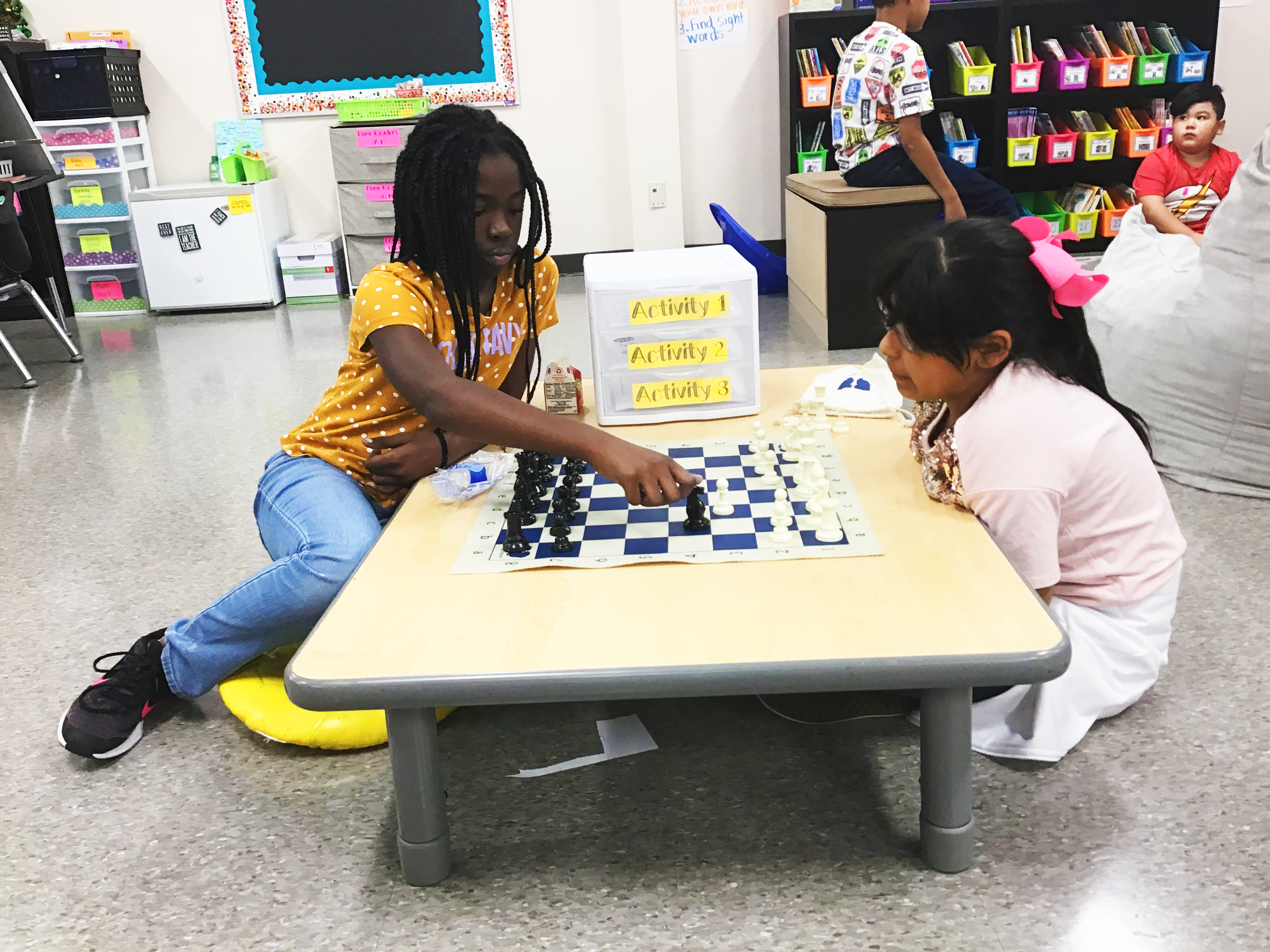 Three girls playing chess